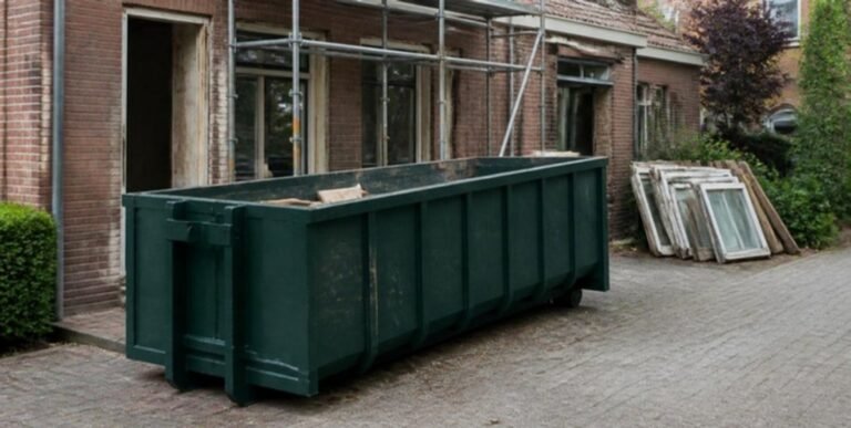 Groene afvalcontainer op een oprit bij een woning in renovatie